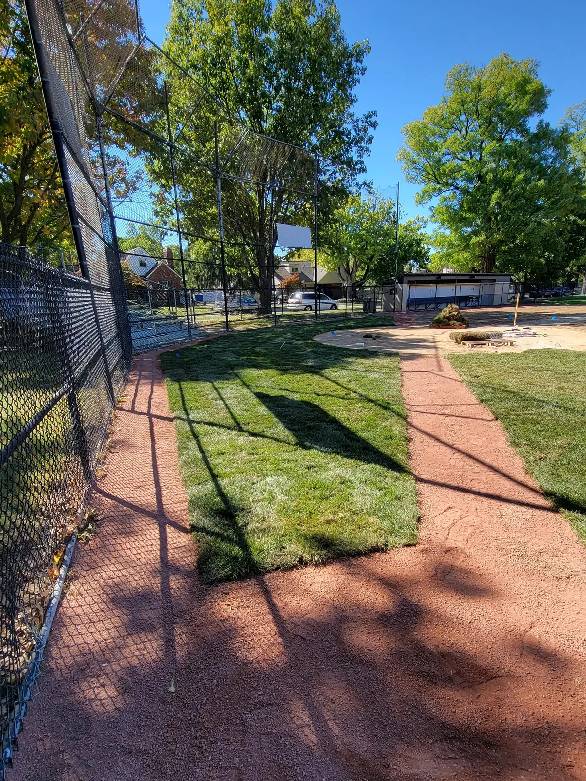 Renovated baseline and infield edge behind a backstop fence, serving Springfield, OH