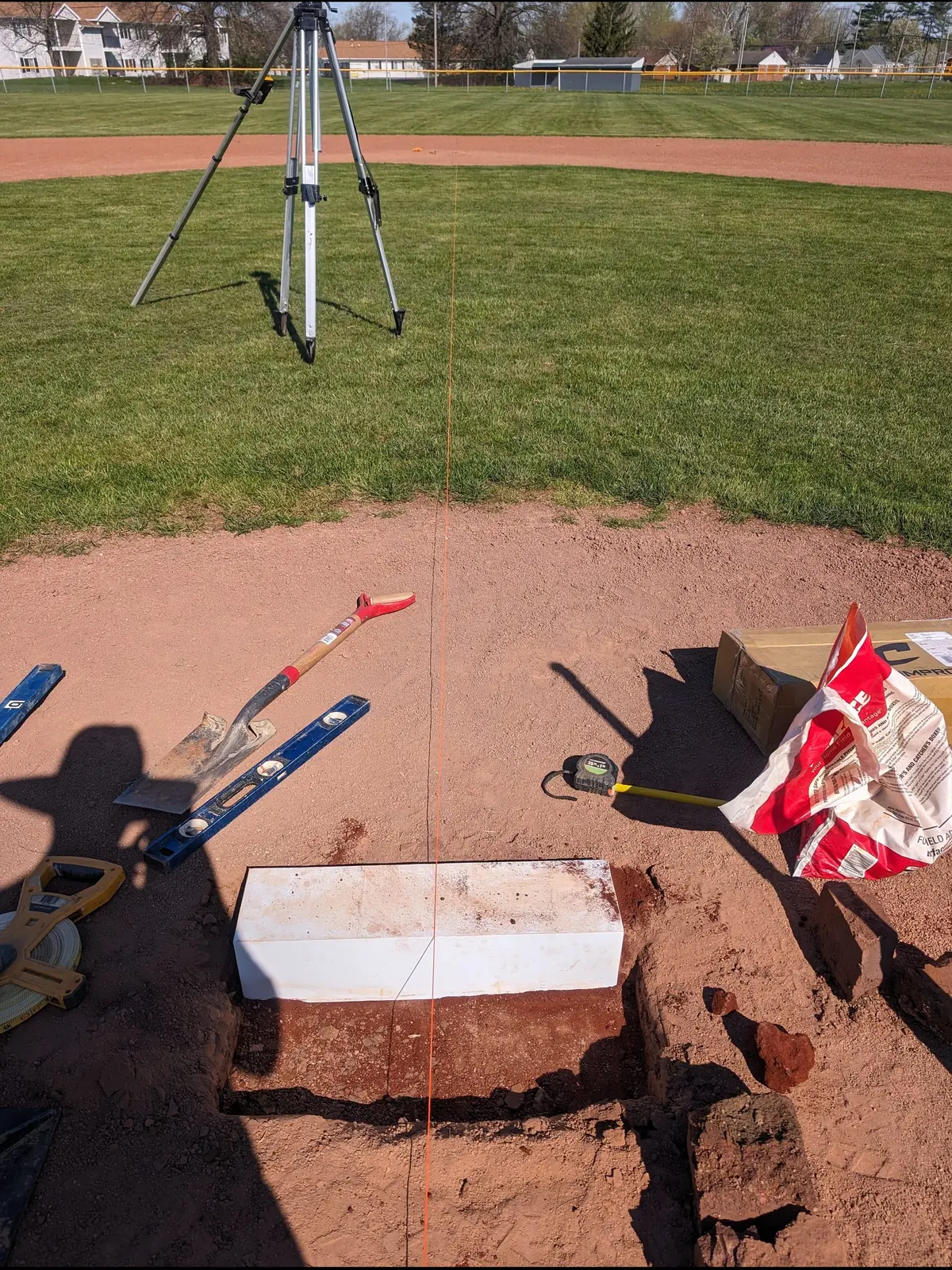 Setting a new pitching rubber on a rebuilt mound with a level and string line, serving Dayton, OH