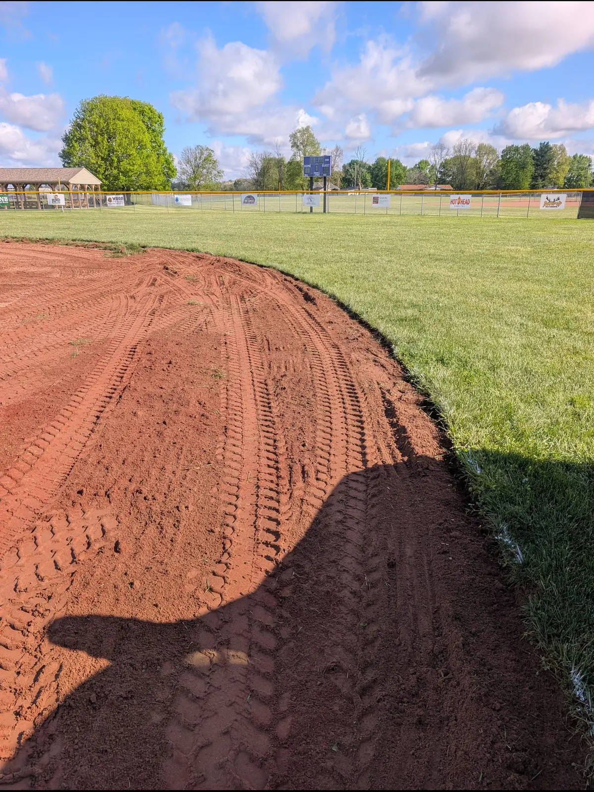 Clean sod-cut edge between red infield clay and outfield grass, serving Dayton, OH