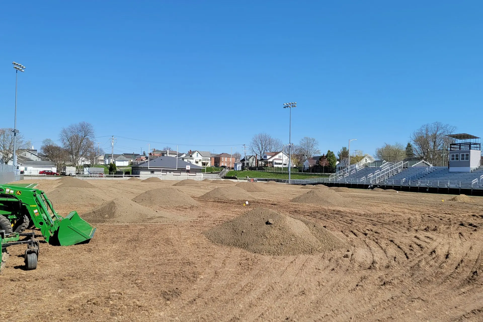 Tractor and grading equipment working a baseball infield during renovation